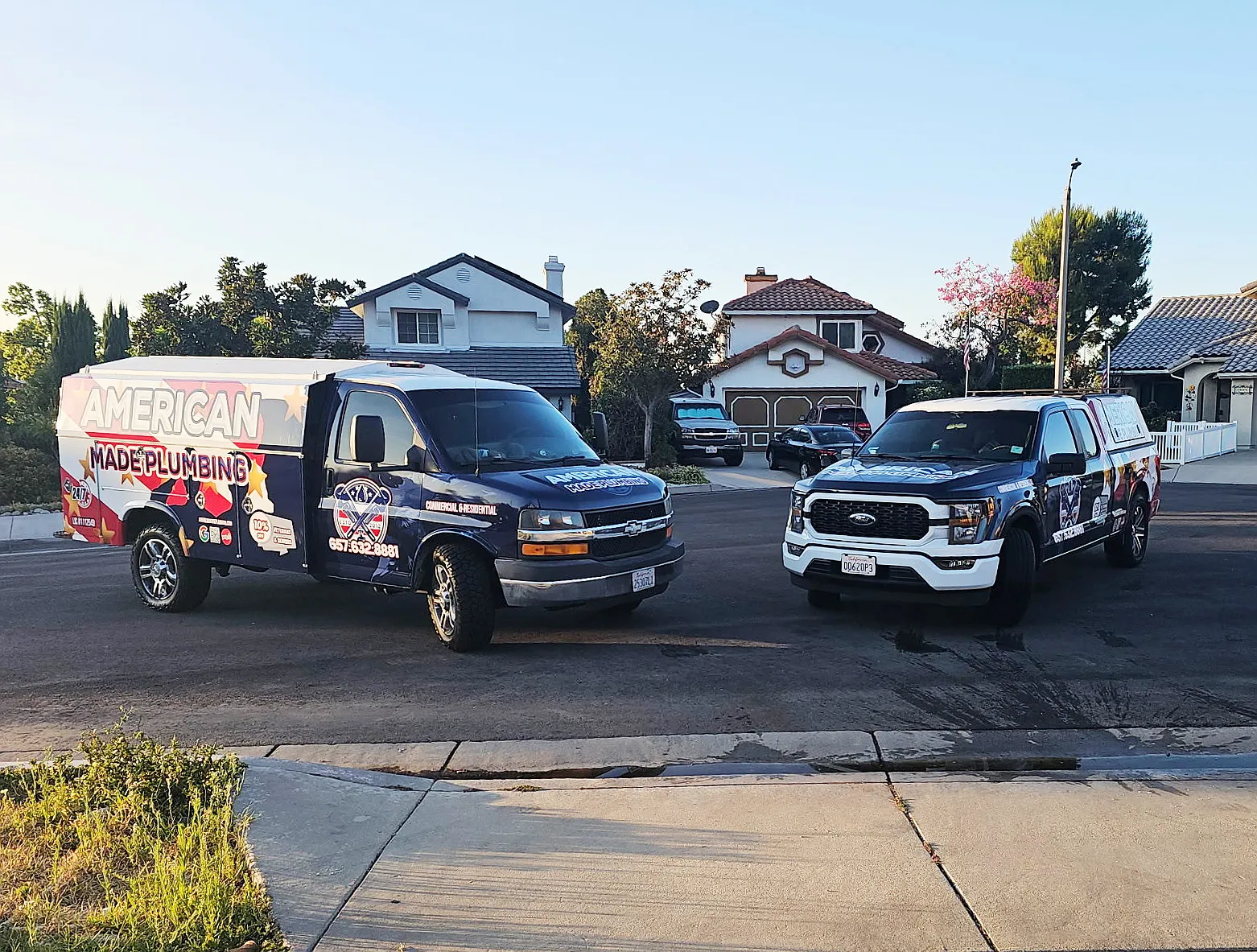American Made Plumbing van and truck parked in a residential driveway
