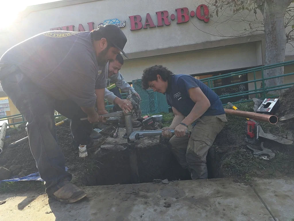 Crew repairing a water line outside a restaurant