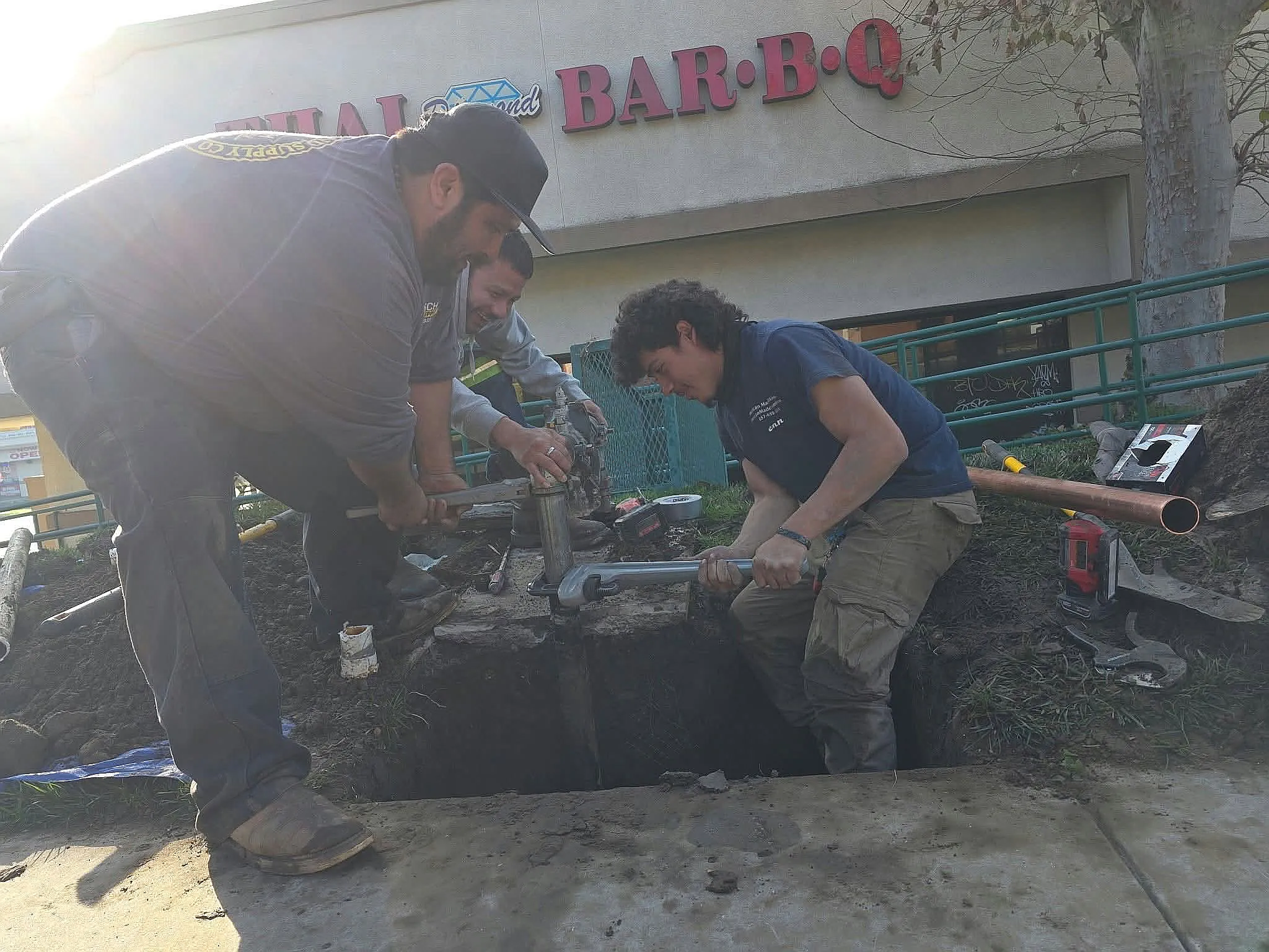 Crew repairing a water line outside a restaurant