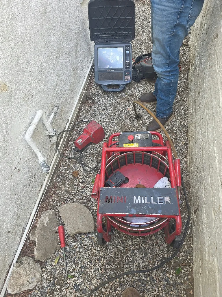 Drain cleaning machine and camera set up in a side yard