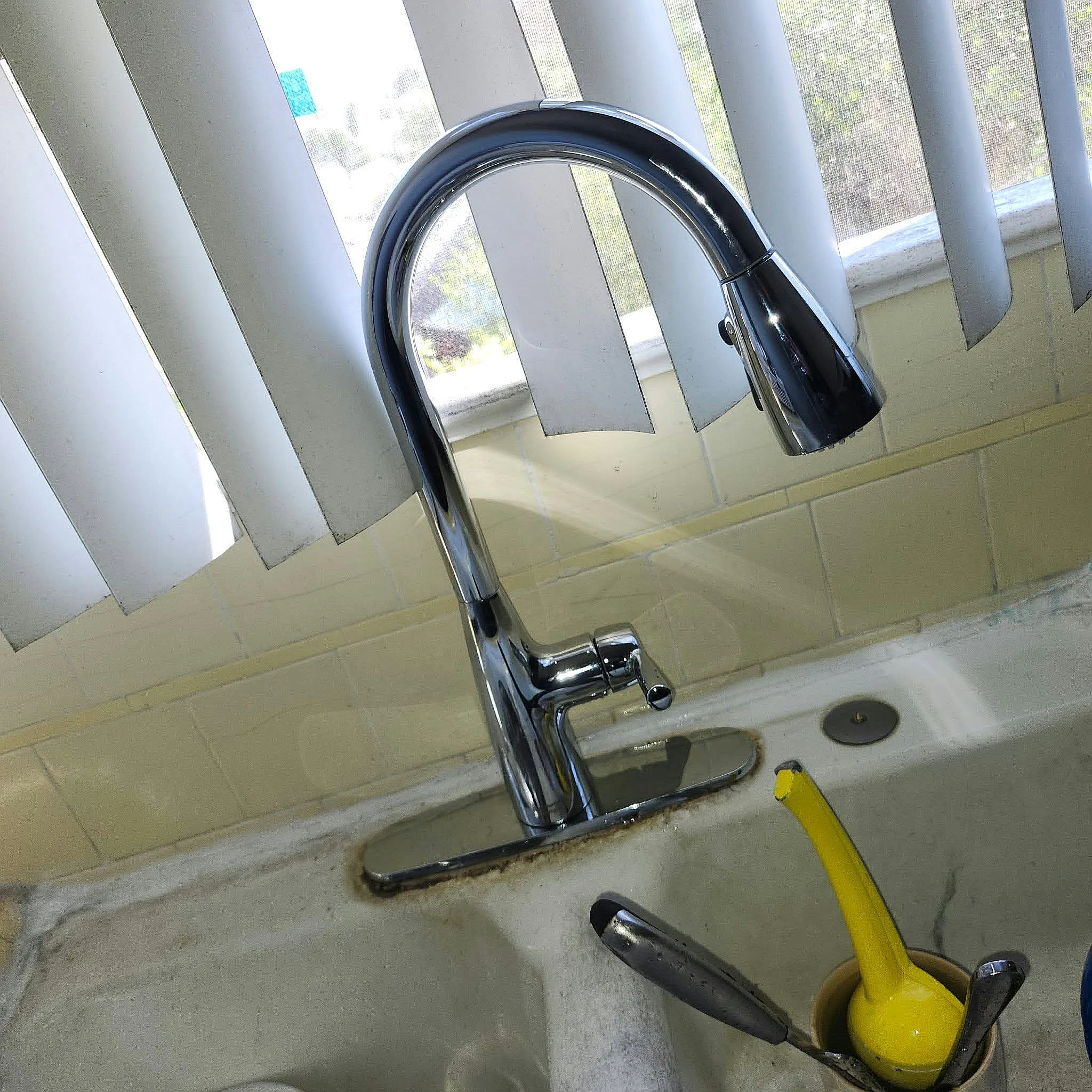 New pull-down kitchen faucet installed at a sink