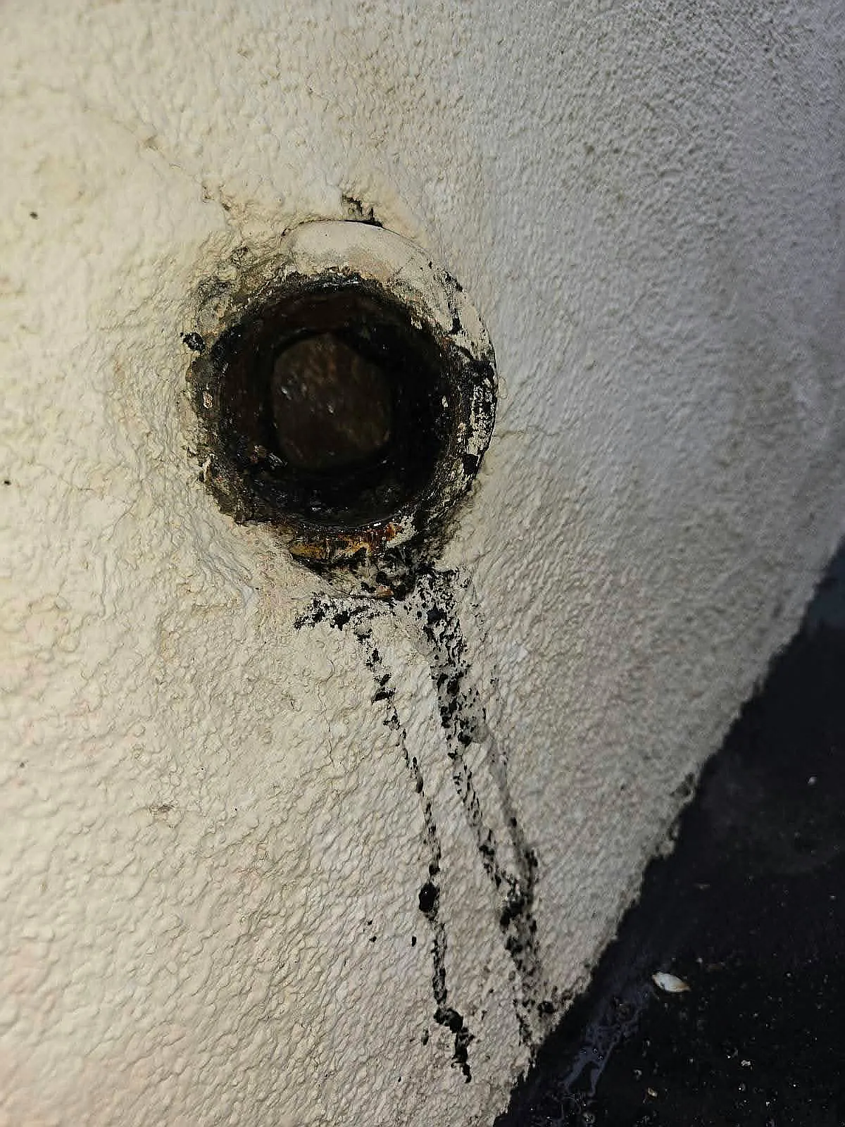 Open sewer cleanout on an exterior wall