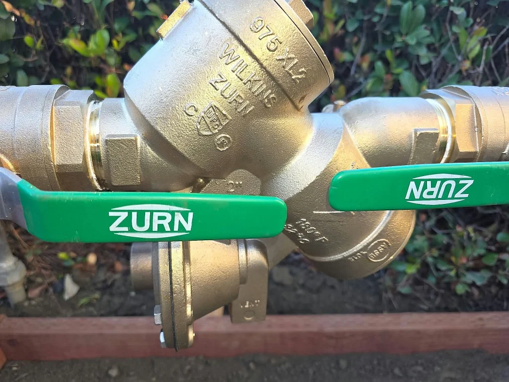 Brass backflow prevention assembly with green shutoff handles
