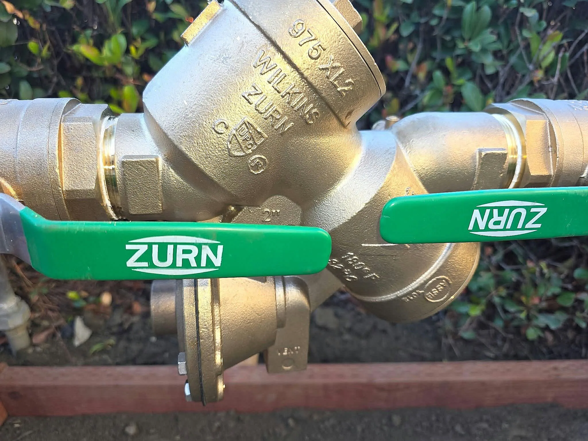 Brass backflow prevention assembly with green shutoff handles