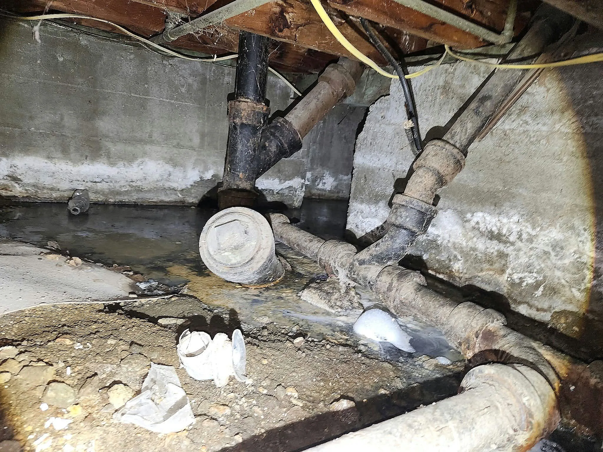 Cast iron sewer pipe and cleanout plug in a crawlspace