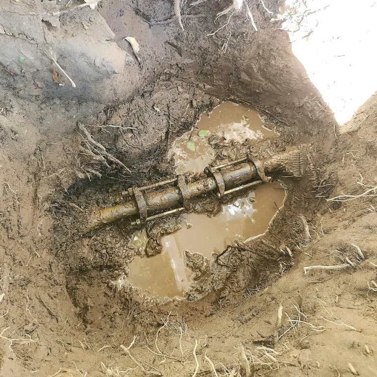 Water pooling around an exposed pipe repair coupling in an excavated hole