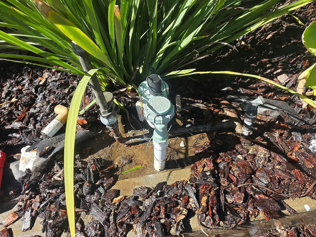 Irrigation valves in a planted garden bed