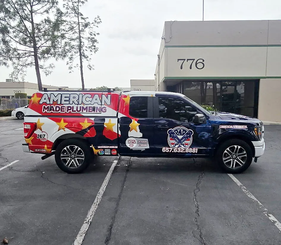 Wrapped American Made Plumbing pickup truck parked outside a commercial building