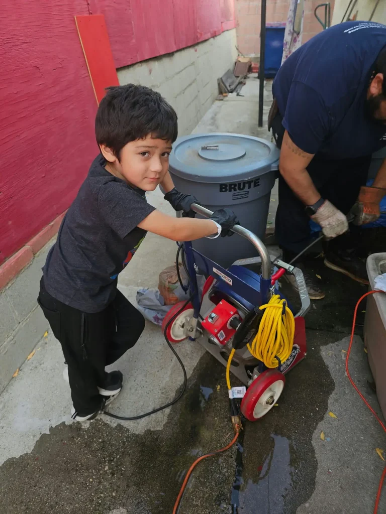 The Kid help out the drain cleaning equipment for pipe service.